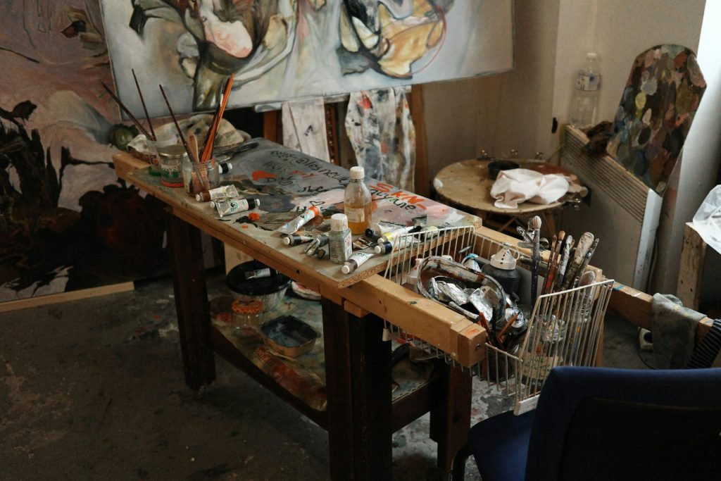 El estudio desordenado de un artista, pinturas y materiales.